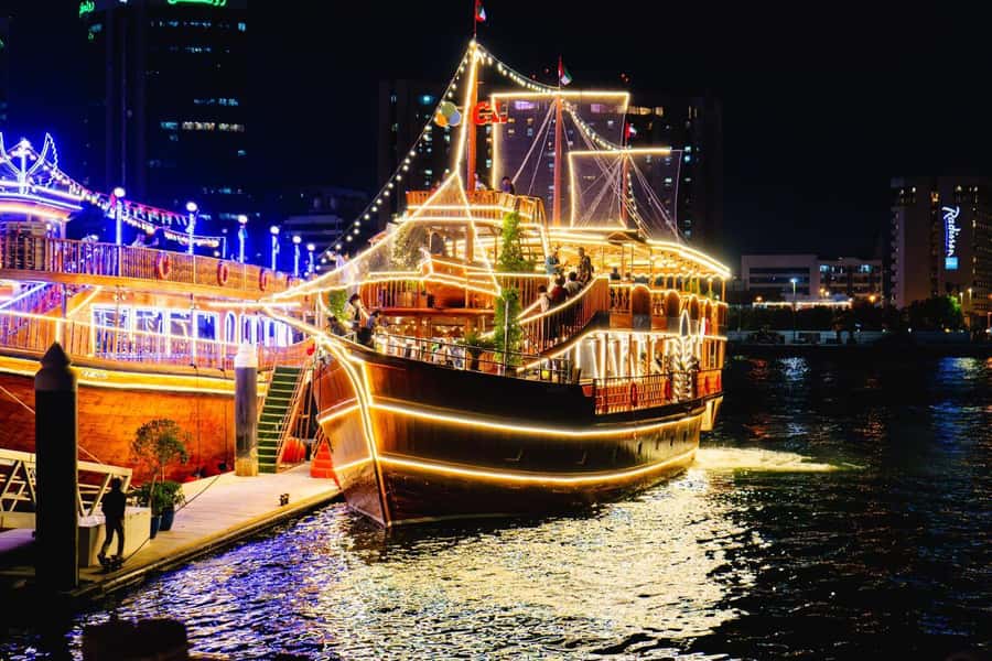 Dubai: Al Seef Largest Dhow Dinner Cruise with Live Show - A traditional dhow with two views of Dubai