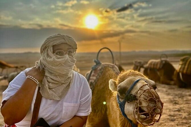 Marrakech Desert Tour & Sunset Camel Ride with Dinner Show - Mounting a camel as the sun goes down